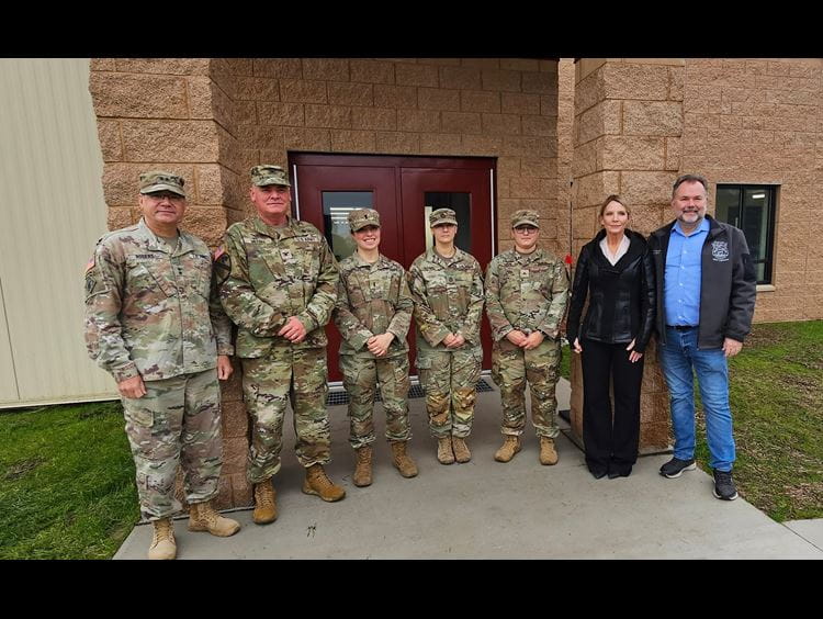 light-skinned men wearing hardhats shoveling dirt at ceremony