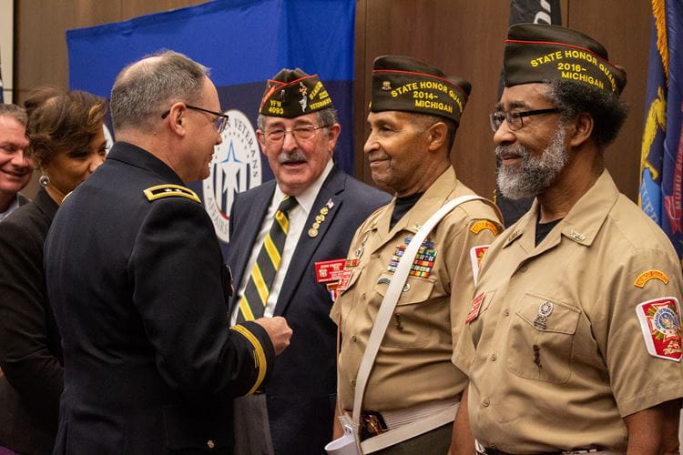 Award recipients stand on stage at the gala displaying their certificate