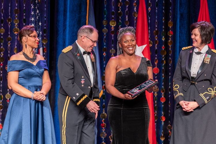 Award recipients stand on stage at the gala displaying their certificate