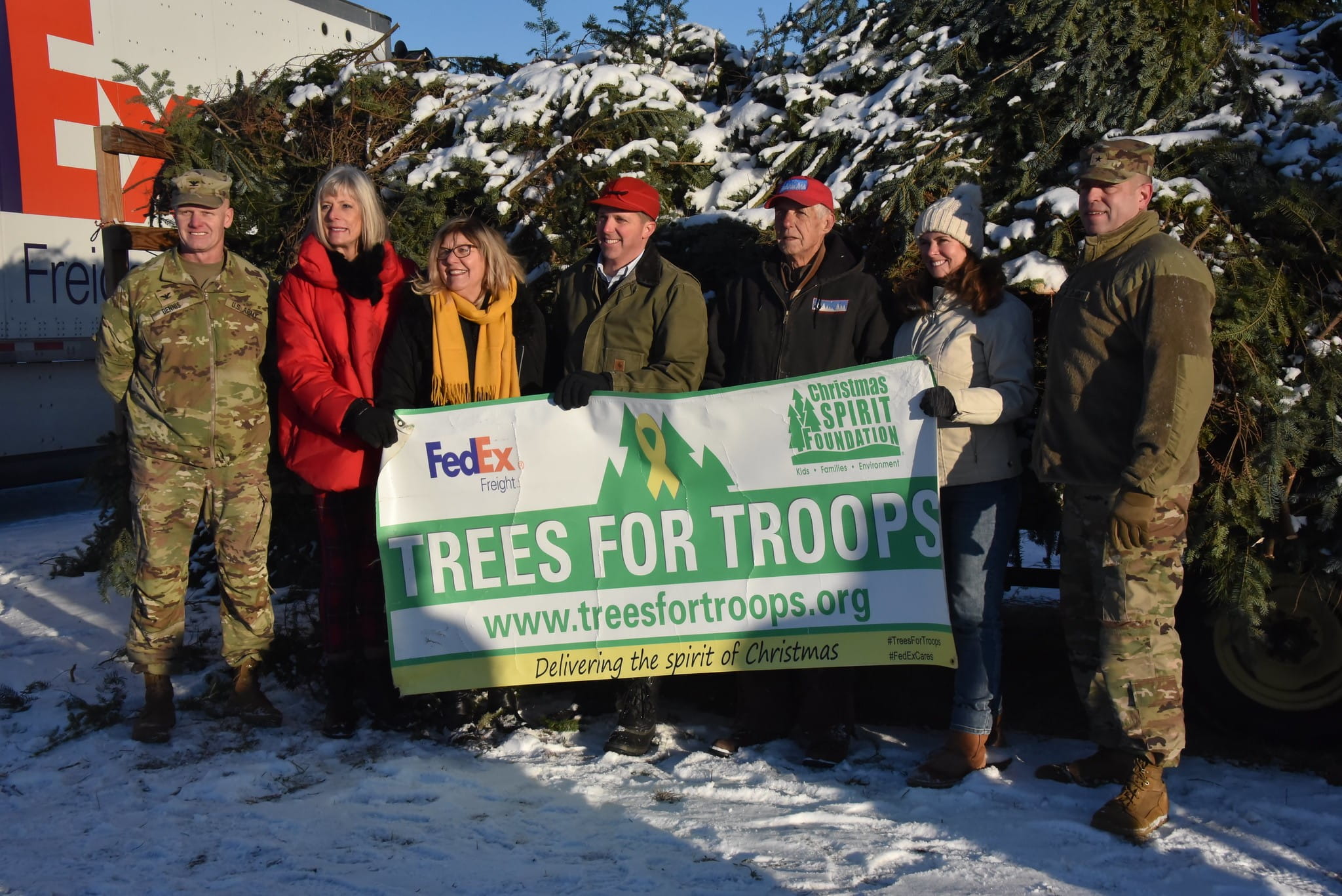 soldiers pose with Christmas trees for troops sign
