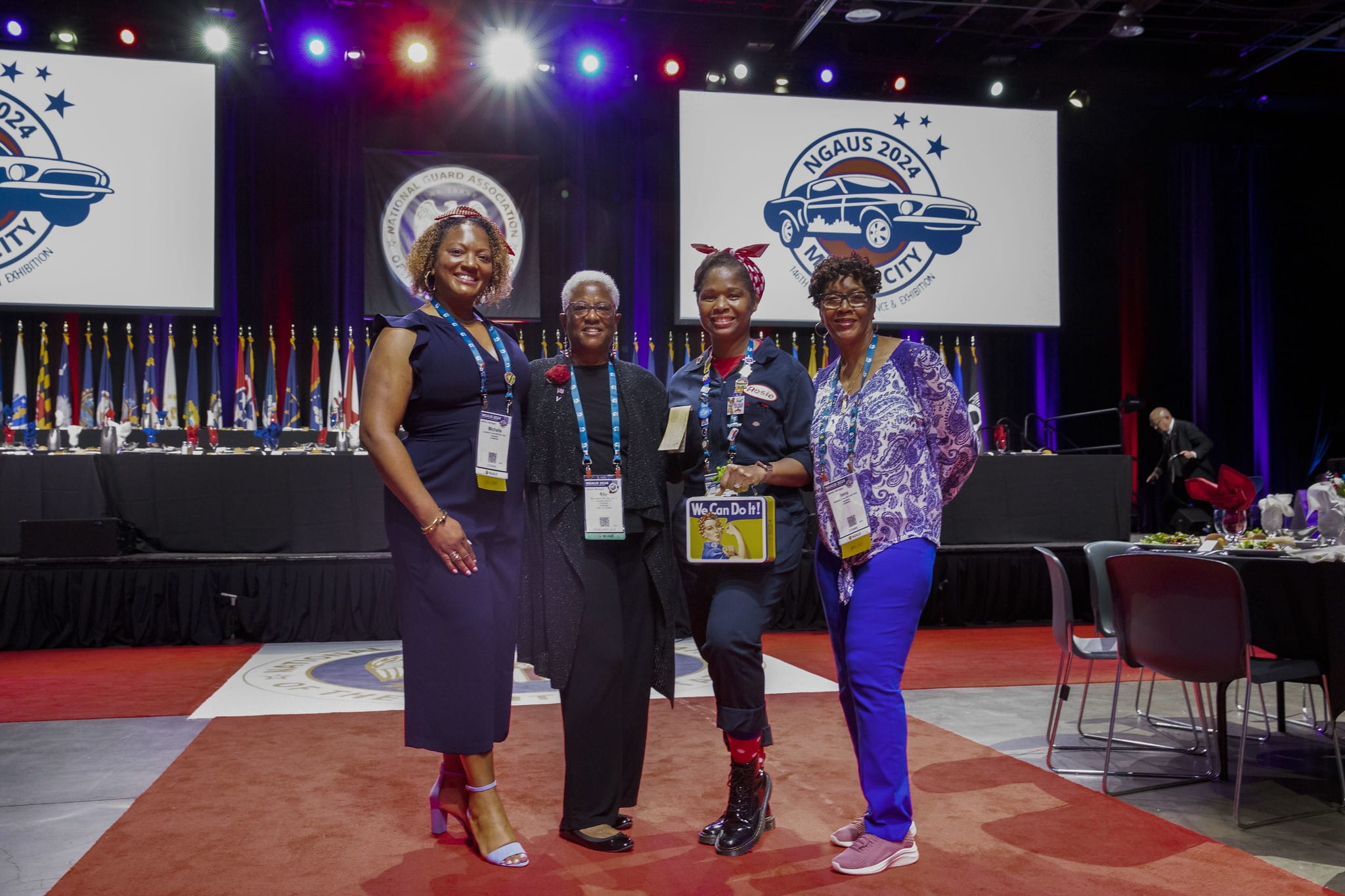 women posing on stage during conference