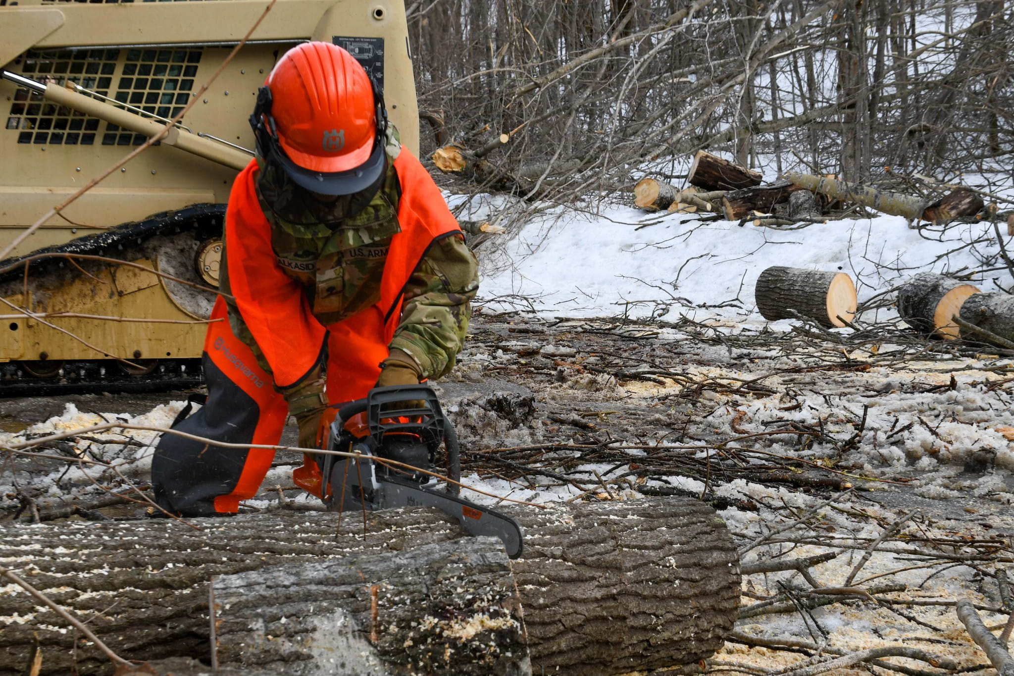 soldier sawing downed tree 