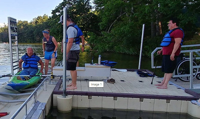 A group of kayakers launching their boats at an accessible kayak launch