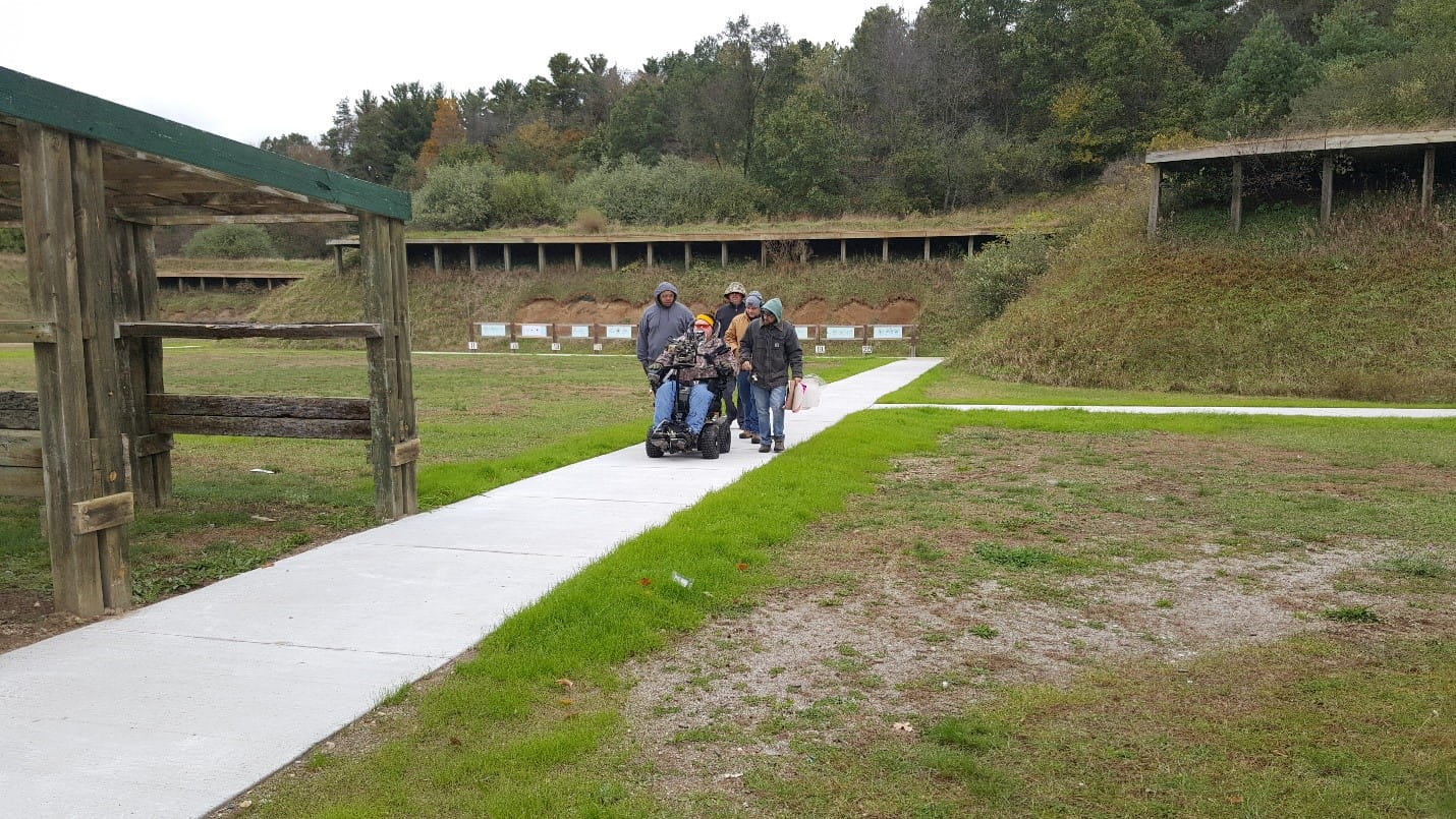 Group of men, one in wheelchair, on accessible path from targets at DNR Sharonville Shooting Range
