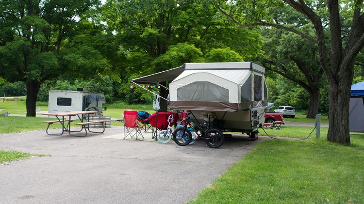 A campground with a cement pad, picnic table and rv