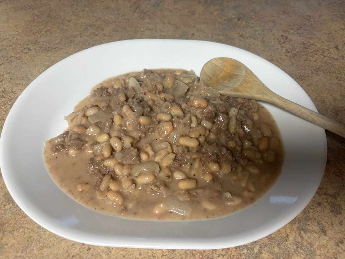 dish of ground venison and beans with wooden spoon