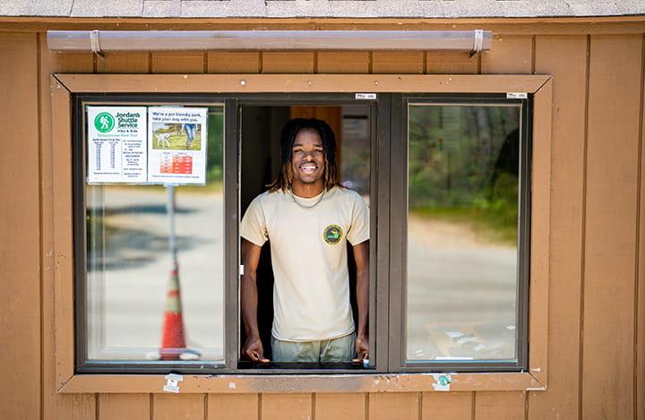 park employee smiling from inside park contact booth