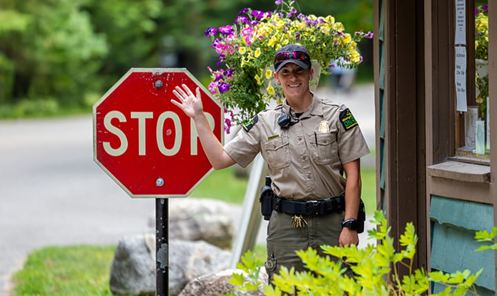 ranger standing outside contact station smiling and waving