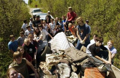 a group of volunteers clean up a dumpsite in a forest