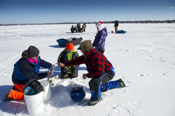 An instructor teaches people proper ice fishing techniques at an OSA Hard Water clinic