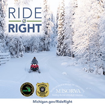 snowmobile riding on path through trees