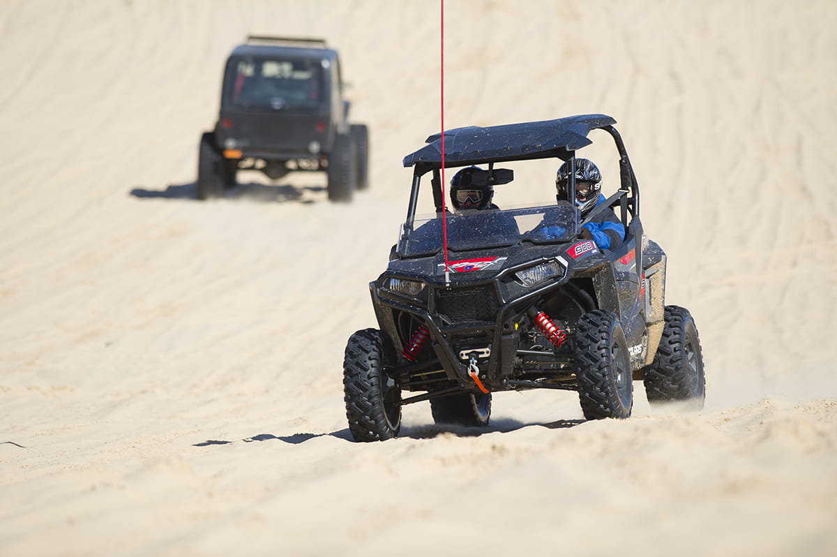 Two side by sides operating on sand dunes