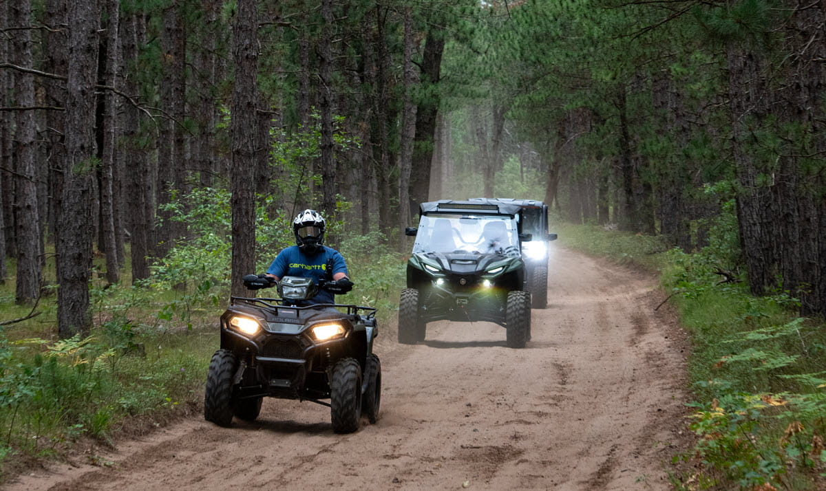 four wheeler and side by side driving in woods