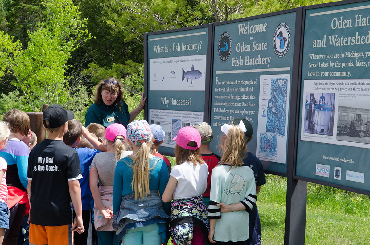 Students gathered around a sign. 
