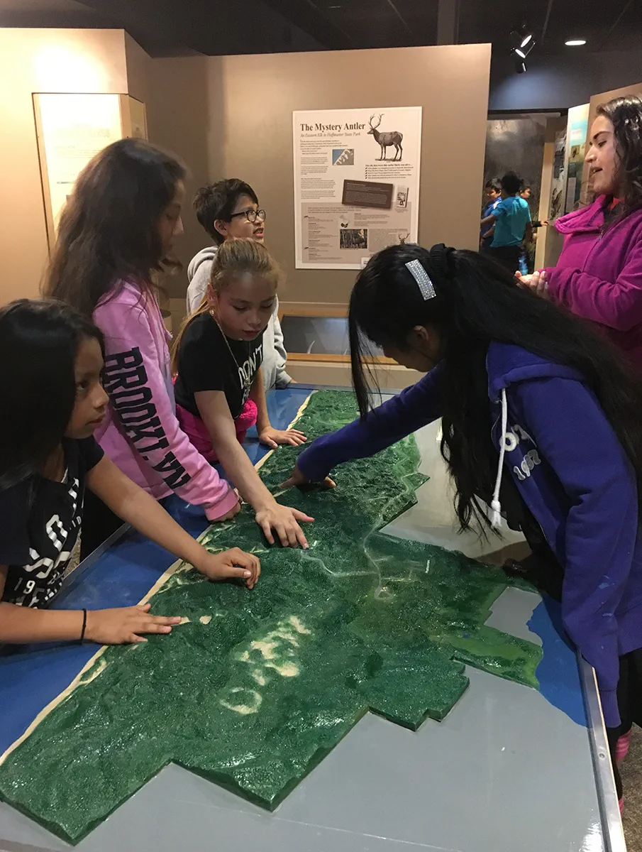 children looking at a topographical map