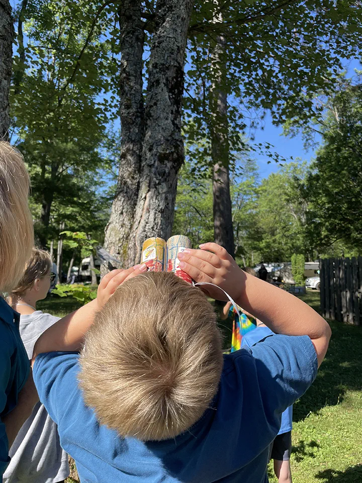 A boy looking up with homemade binoculars