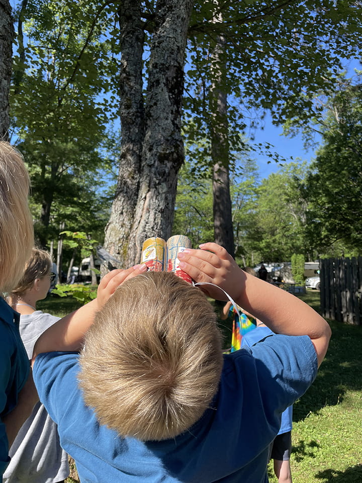 A boy looking up with homemade binoculars
