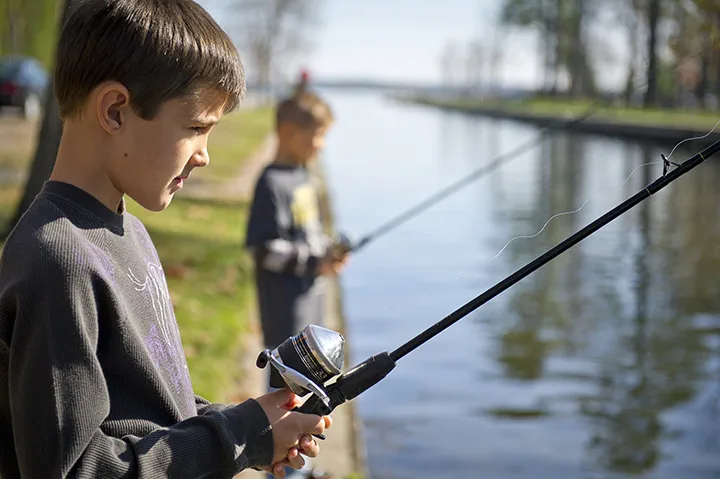 Two boys fishing on the canal next to the Carl T. Johnson Center