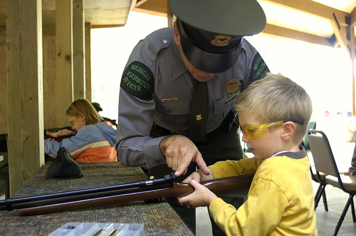 A young boy being instructed by a ranger