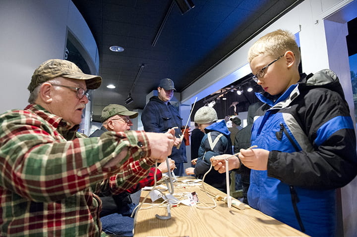 A volunteer shares with a boy during a fishing program