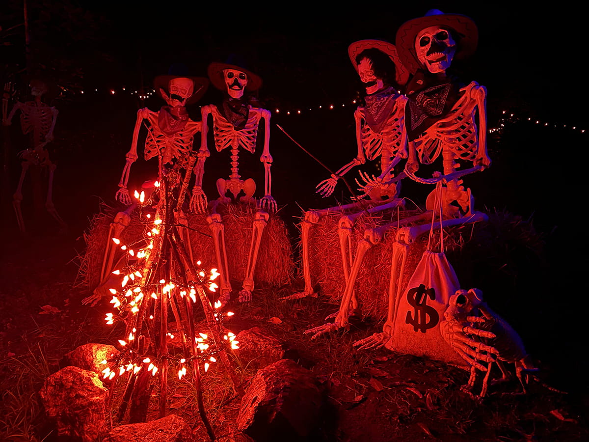 skeletons dressed up with hats and bandanas around red Christmas light "fire"