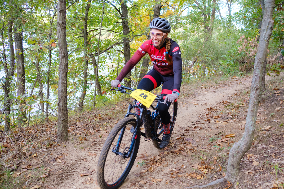 Woman riding a mountain bike on a trail through the trees at Fort Custer Recreation Area