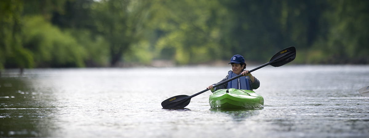 Woman paddling on river with lifejacket