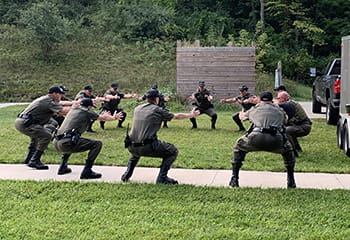 officers standing in a circle outside performing stretches