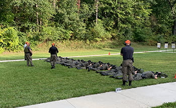officers laying in the grass target shooting with rifles