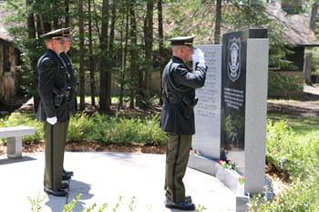 officers salute a memorial grave