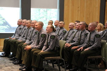 Group of people sit, smiling watching a presentation