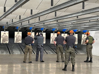 people shooting at indoor shooting range