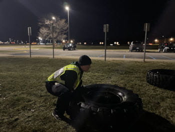 man flipping a large tire outside