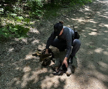 person inspects dead, small game on a road