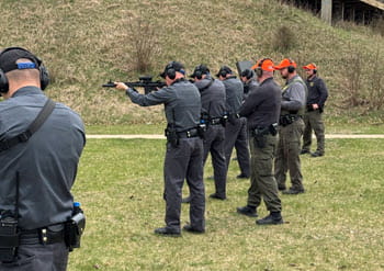People safely shooting firearms at an outdoor shooting range