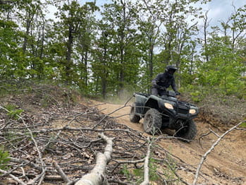 person operating a four-wheeler down a hill