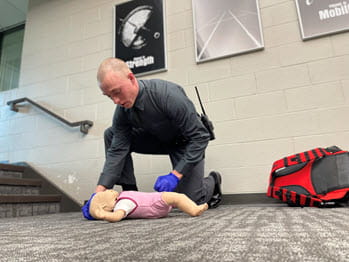 man evaluating a baby doll during first aid scenario