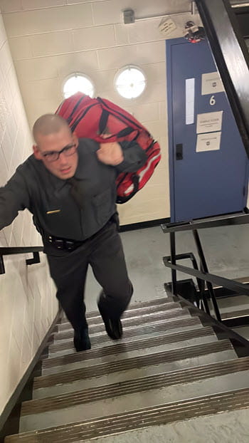 man carrying a first-aid bag up stairs