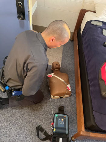 man using an AED on a training doll