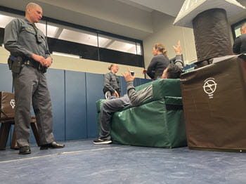 officers in training talking to two actors in a scenario room