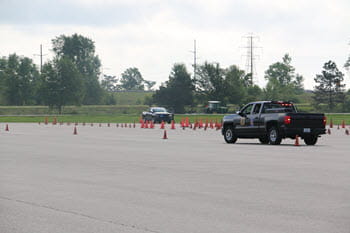 A patrol truck navigates through a cone course