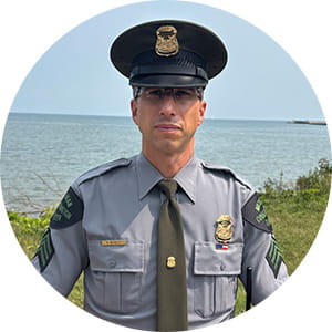 CO Bucholtz in uniform in front of lake