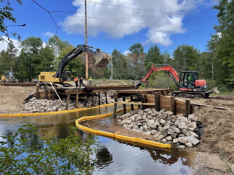 A dam being worked on with construction vehicles in the background