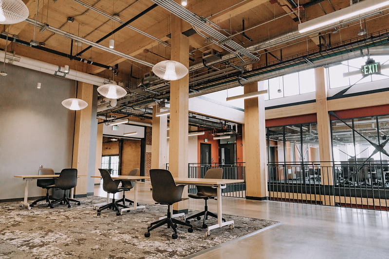 An open space built of mass timber with an industrial look and warm, modern wood paneled ceilings and beams