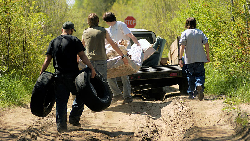 A team of volunteers cleans up trash and discarded tires from the forest
