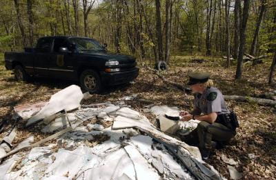 a DNR conservation officer inspects a suspected dumpsite
