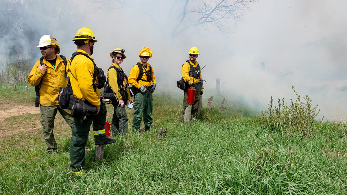 A group of firefighters plan their actions during a prescribed burn
