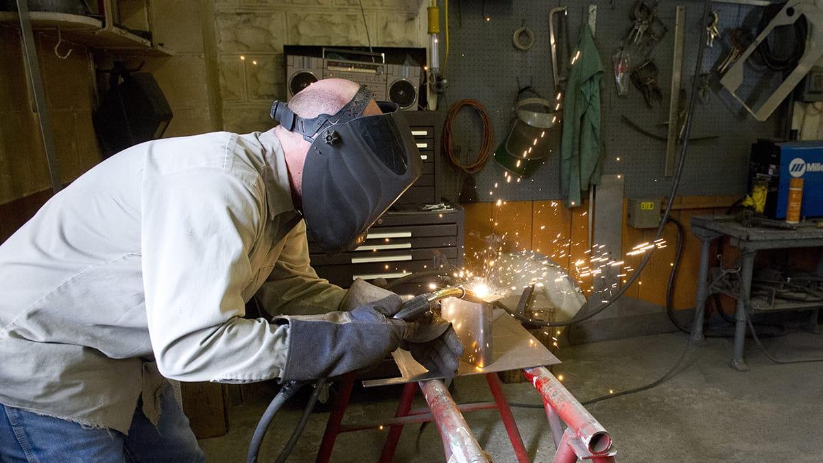A welder works with equipment at the forest fire experiment station