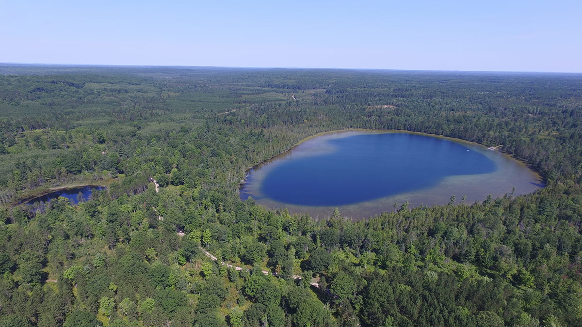 Aerial image of Walled Lake in the middle of a lush forest
