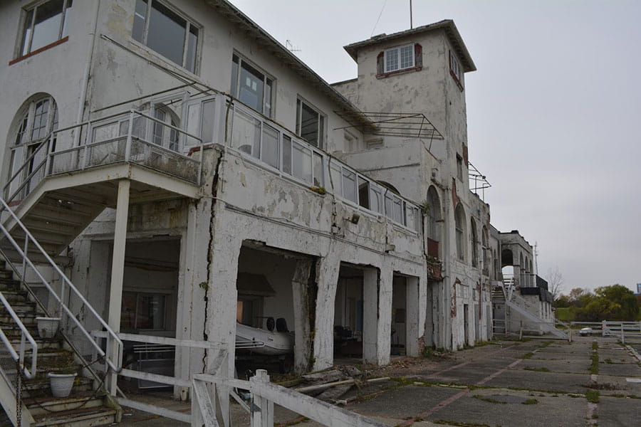 Outside of building with rust, concrete spalling, and cracks in support beams.